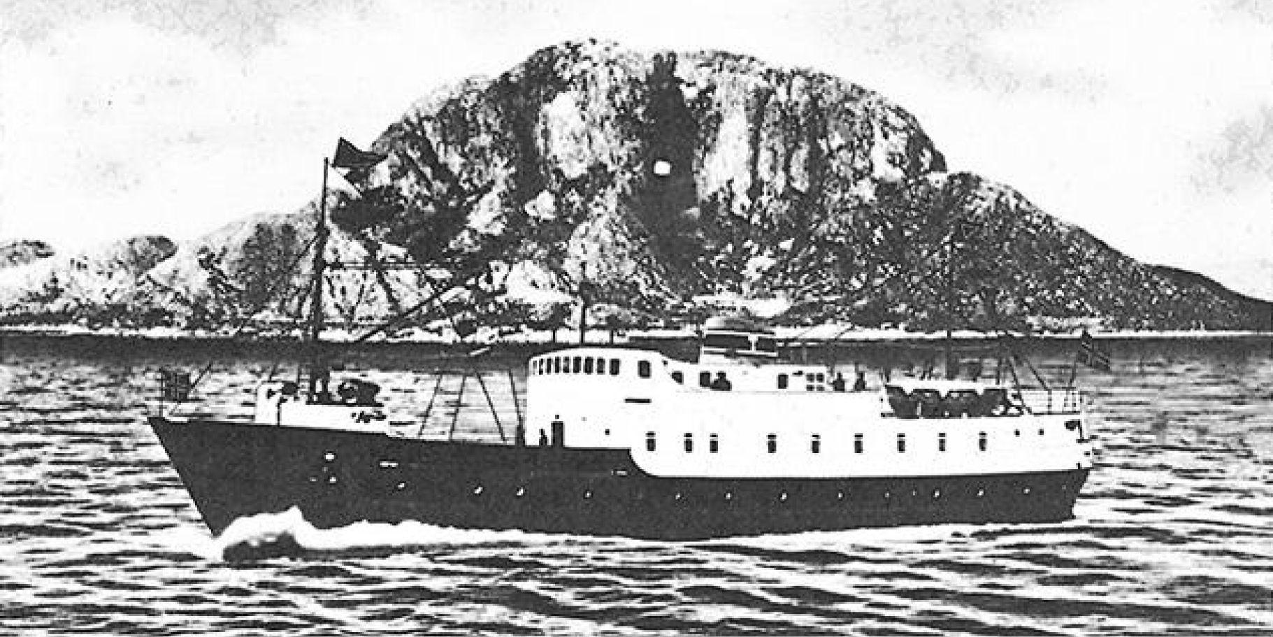 Skipet Torghatten på sjøen med fjellet Torghatten i bakgrunnen. 